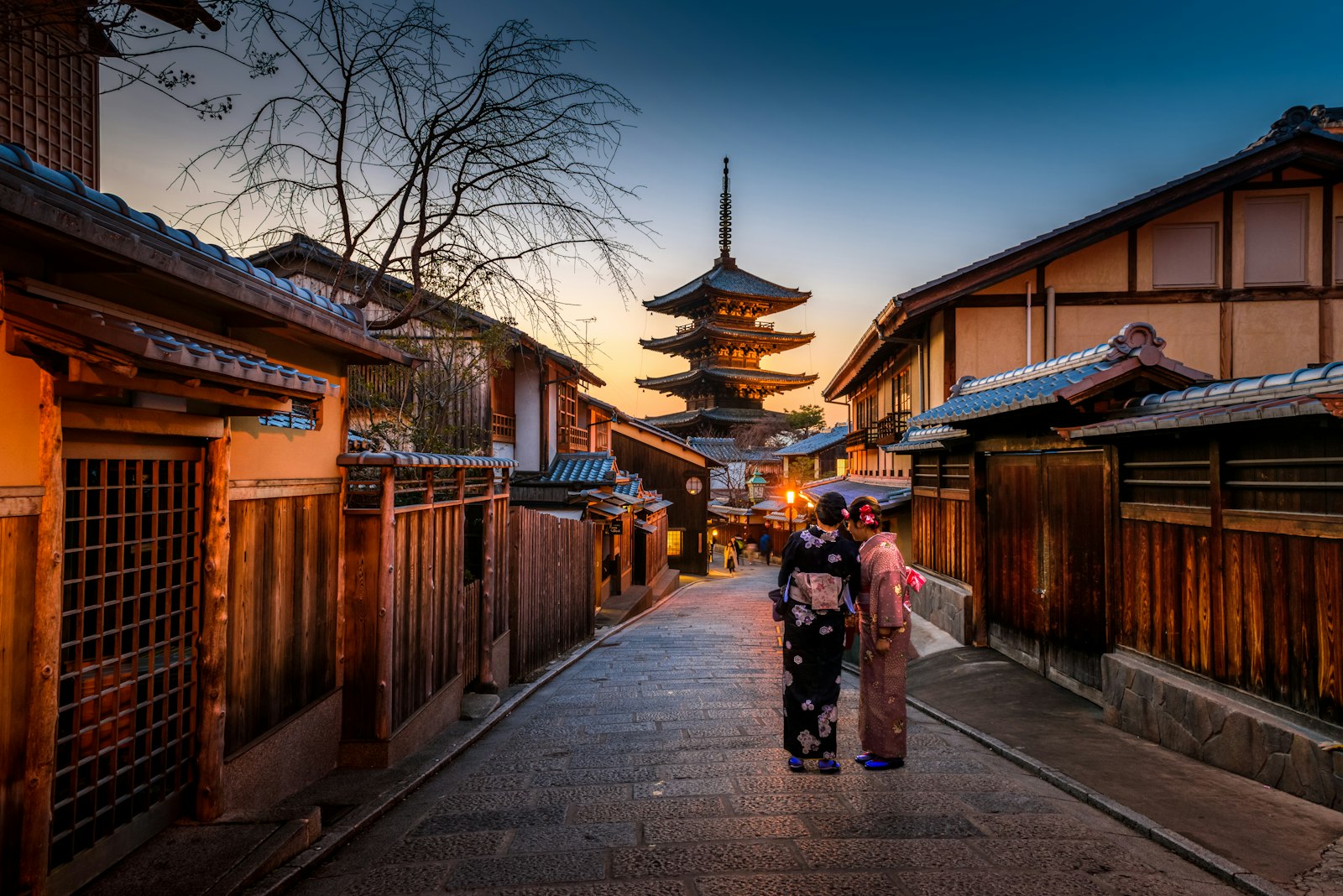 Calle tradicional de Kioto con pagoda al fondo y dos personas en kimono
