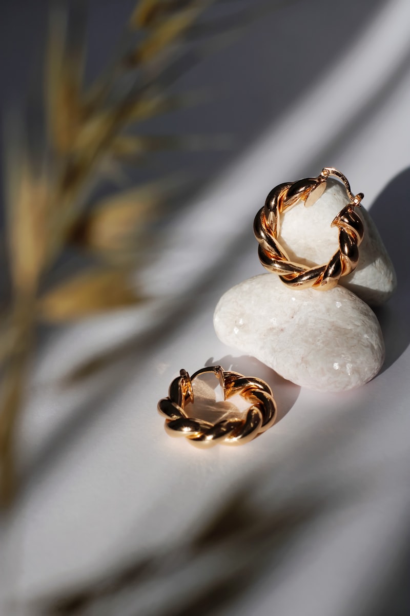 Argollas doradas sobre piedra con luz puntual