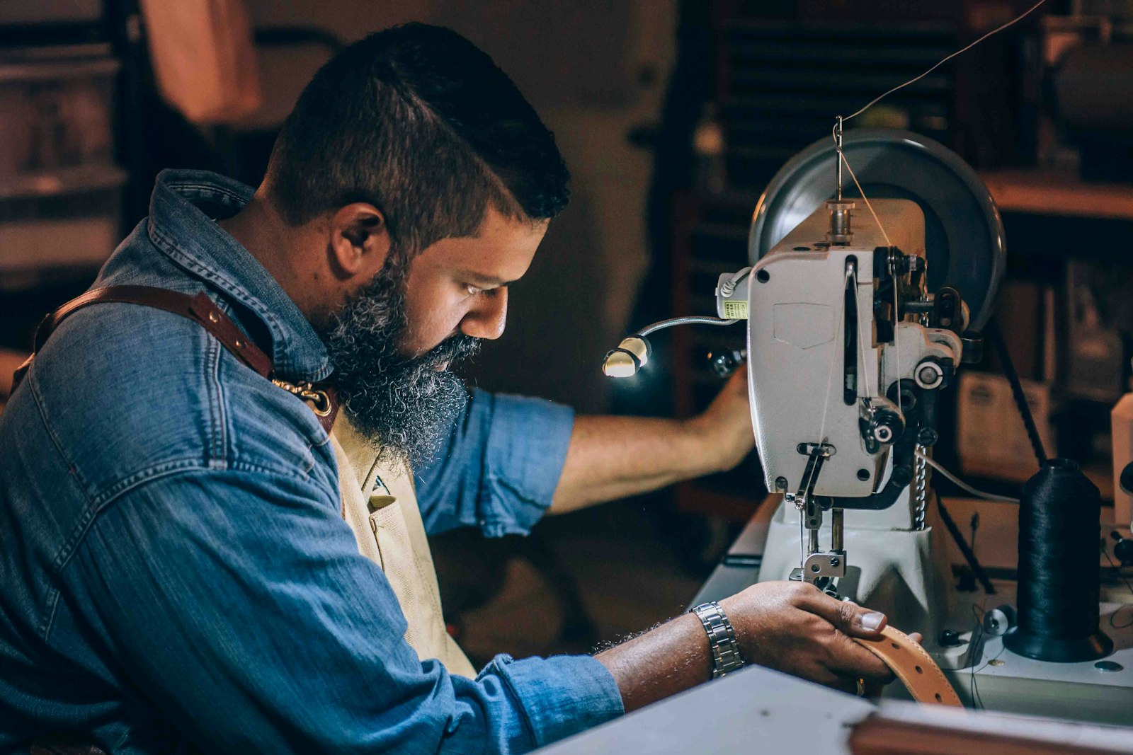 Artesano cosiendo a máquina en el atelier de Maison Vela