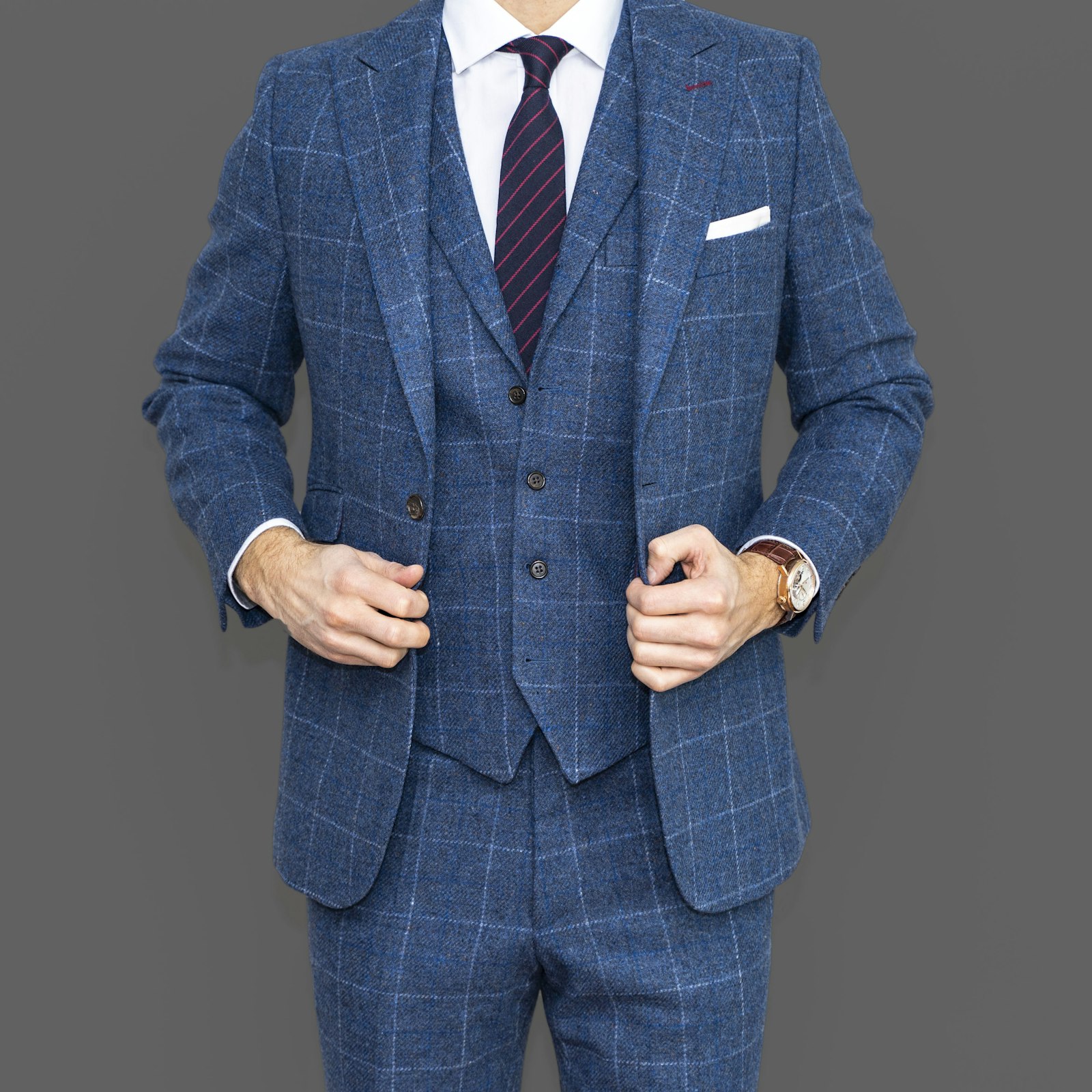 Traje de tres piezas azul sobre fondo gris