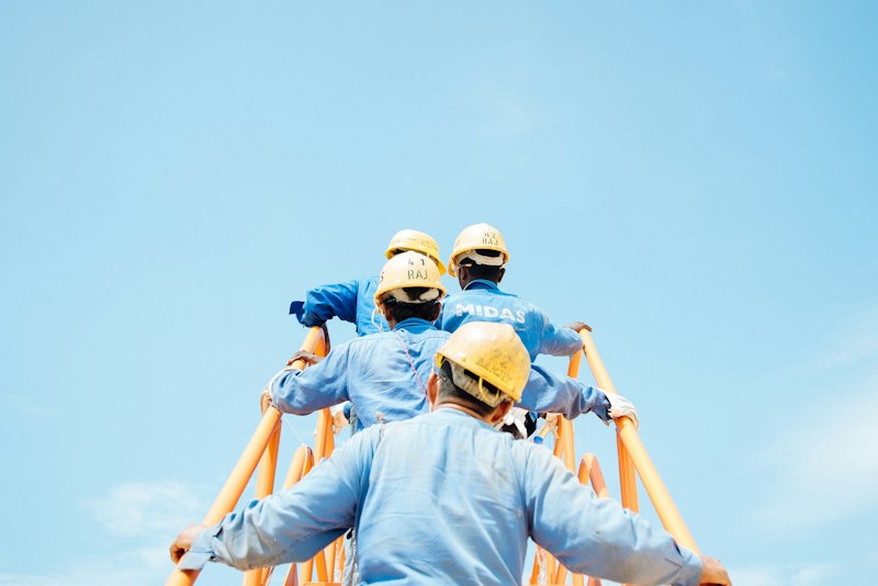 Cuadrilla con cascos subiendo estructura