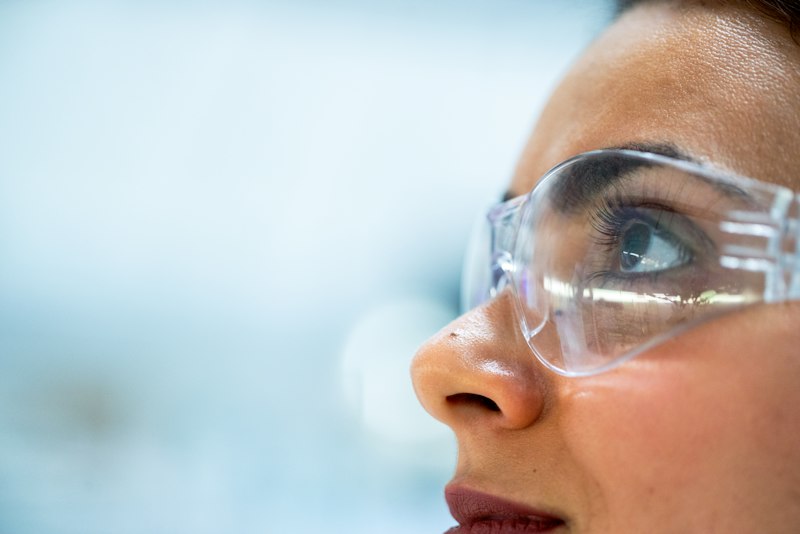 Detalle de lentes de seguridad sobre el rostro de una técnica