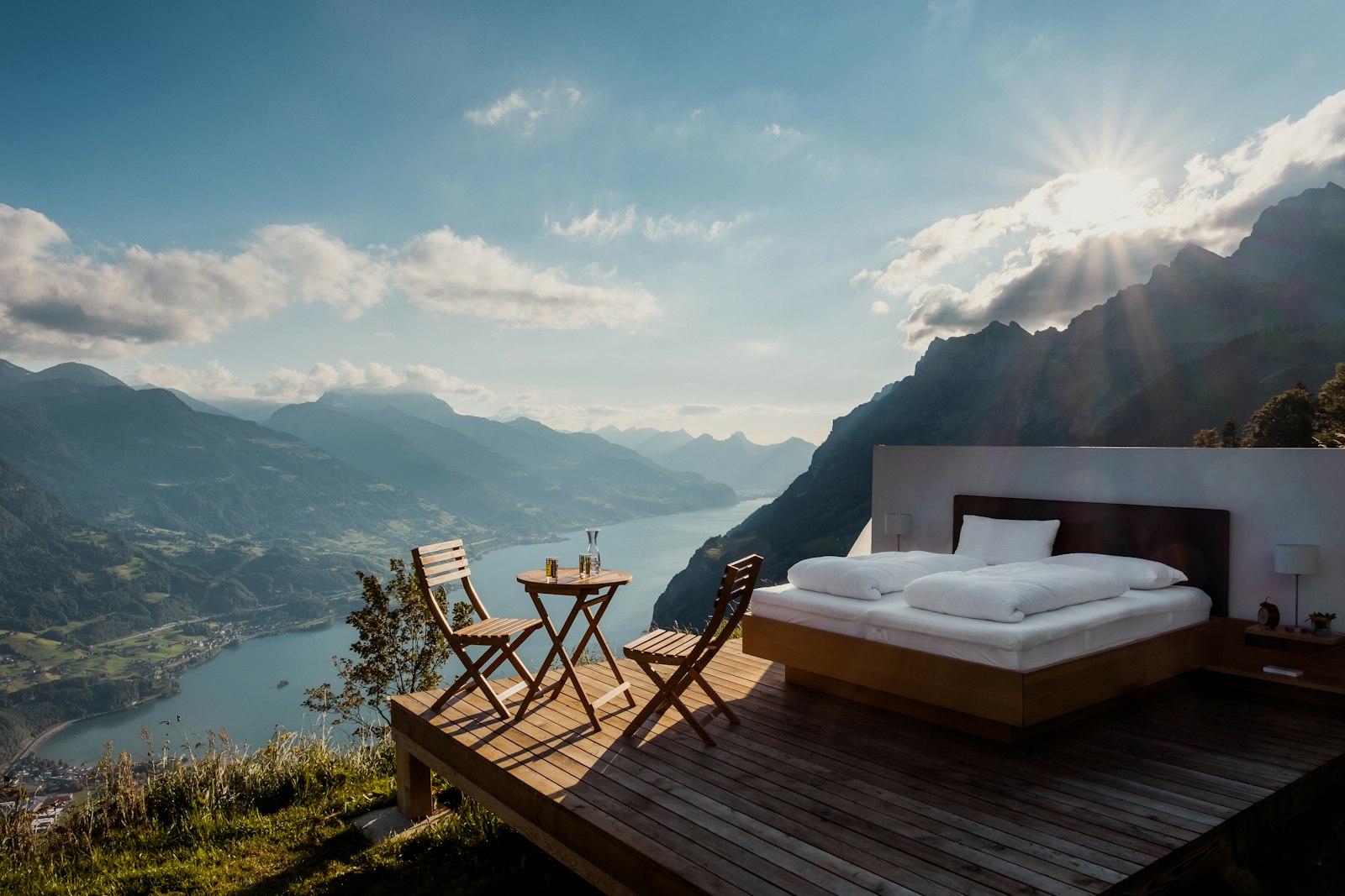 Cama al aire libre sobre una terraza de madera frente al horizonte