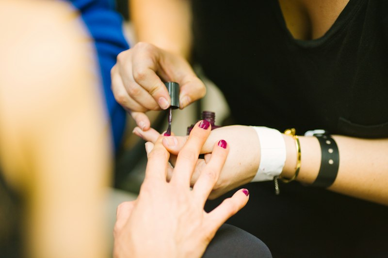 Aplicación de esmalte ciruela en manicura