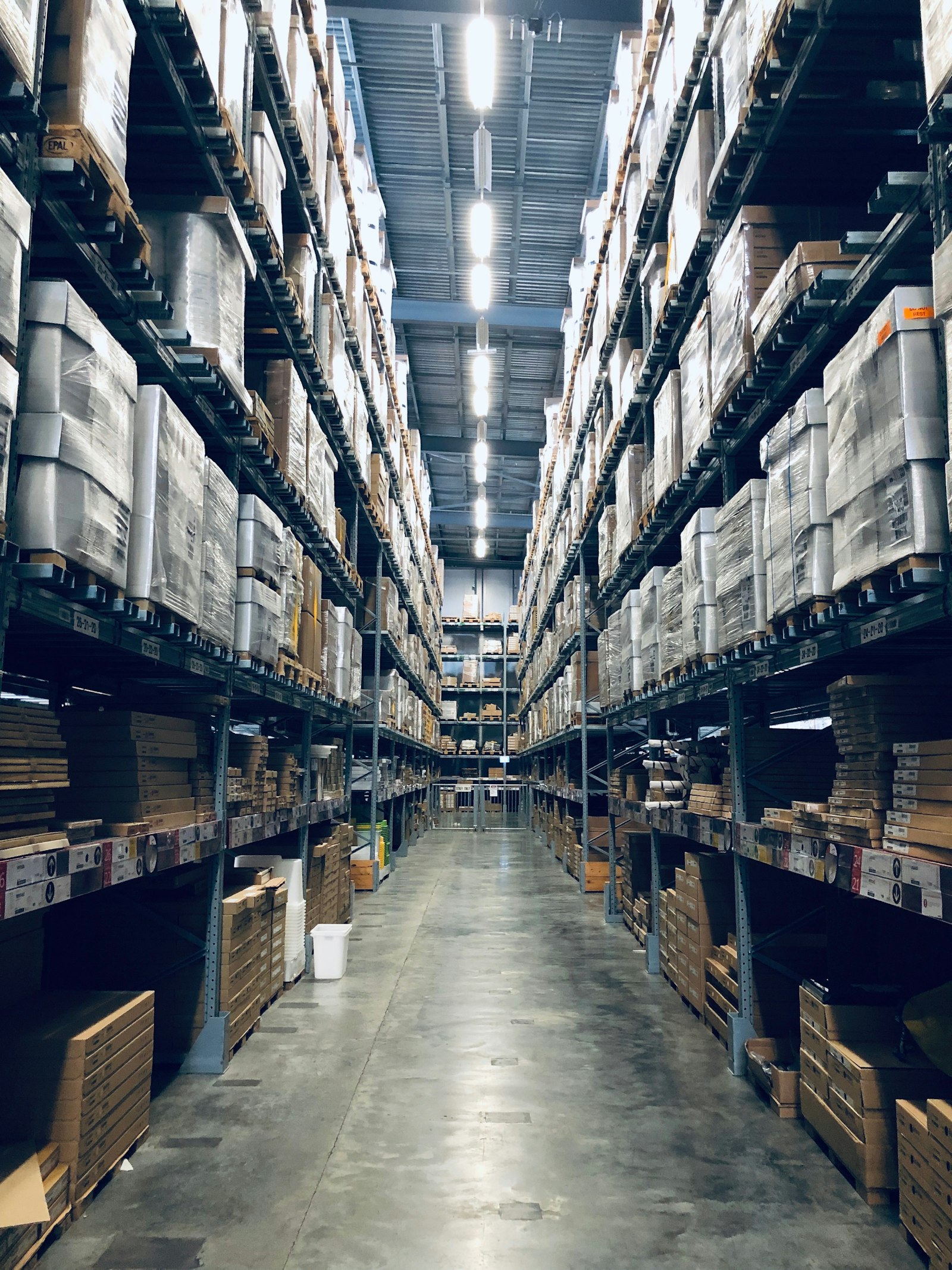 Pasillo de bodega con racks industriales llenos de mercancía