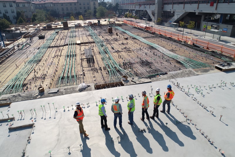 Cuadrilla con cascos y chalecos supervisando una obra